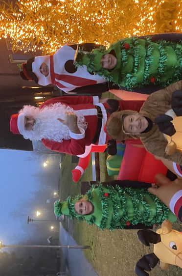 En gruppe mennesker utkledd som julenissen som sitter i en sofa